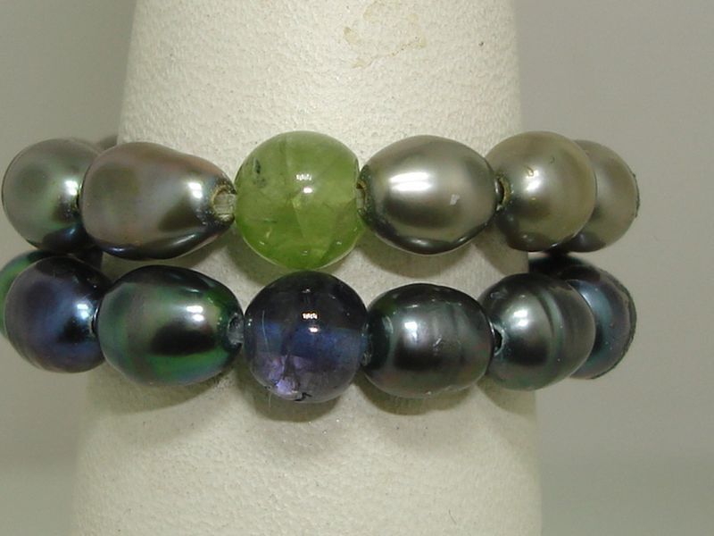 Pair of stretch rings with a green freshwater pearl and a purple freshwater pearl
