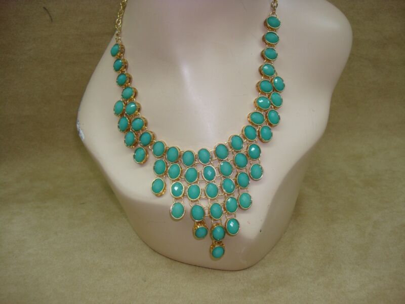 Contemporary gold tone bib necklace with teal glass stones