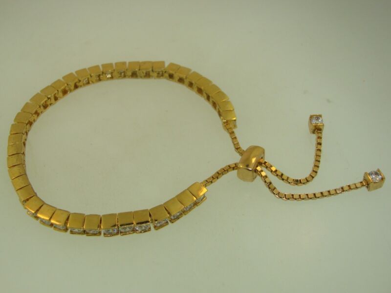 Gold-tone CZ tennis bracelet with adjustable slider design, sparkling crystals