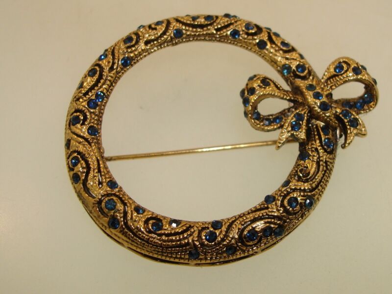 Vintage gold-washed filigree brooch with blue rhinestones