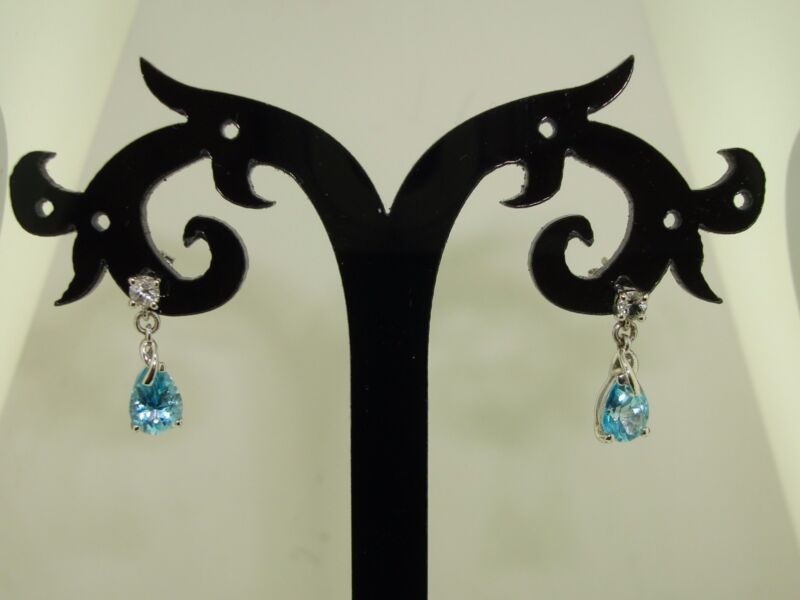 10K white gold topaz dangle earrings with blue pear-shaped topaz gemstones.