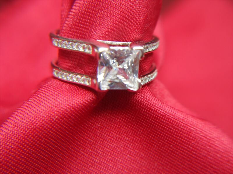 Sterling silver cocktail ring with large princess-cut cubic zirconia and side stones.