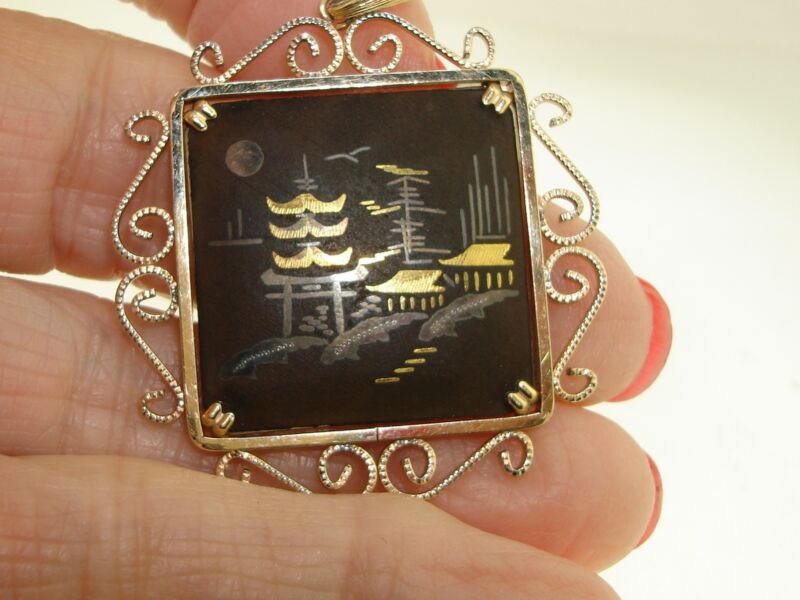 Vintage damascened pagoda scene pendant with filigree frame and black enamel