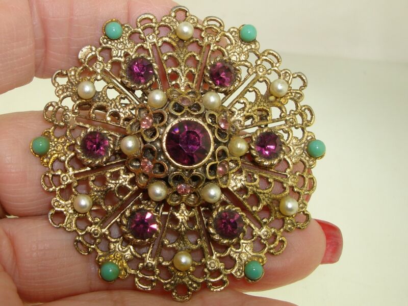 Vintage filigree pin from the 1950s-60s featuring rhinestones, faux pearls, and turquoise.