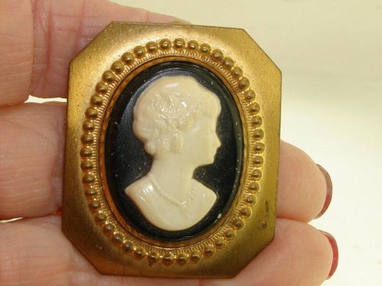 Antique gold-washed cameo pin/pendant with a black and white molded profile of a young lady