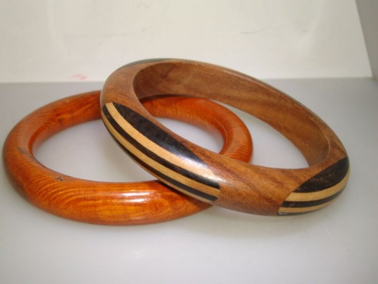 Two vintage wooden bangle bracelets from the 1970s, one with a grained finish and the other with an inlaid design. Excellent condition.