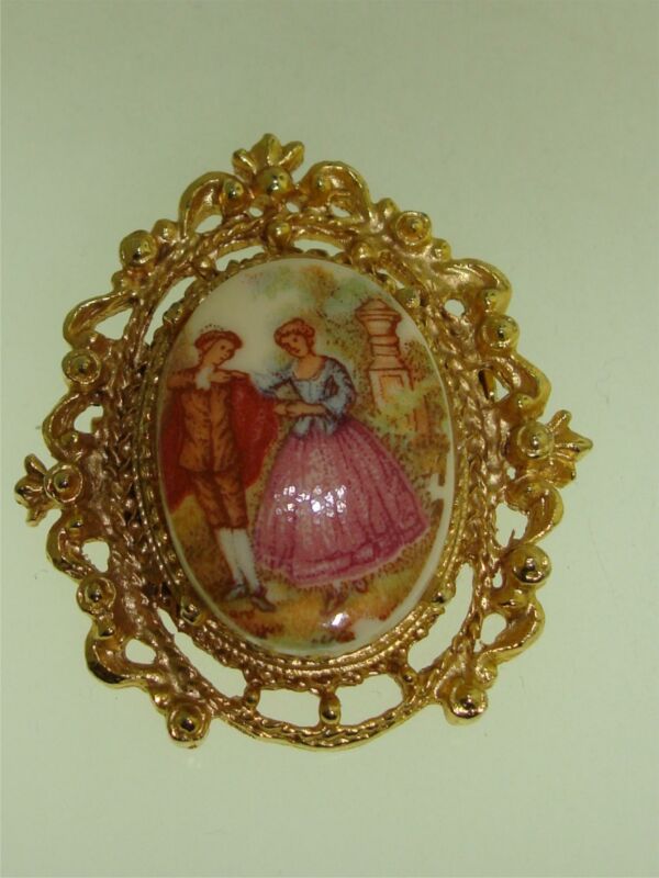 Vintage gold tone filigree porcelain brooch with a colonial scene