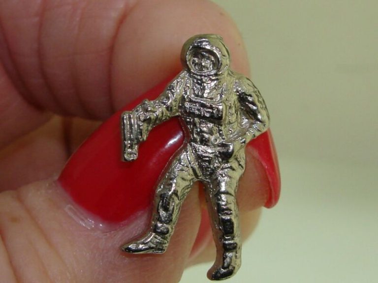 Vintage silver tone astronaut lapel pin with space gun detail