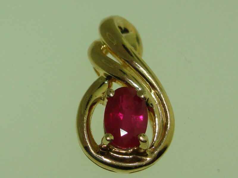 14K gold ruby pendant with a faceted double swirl design