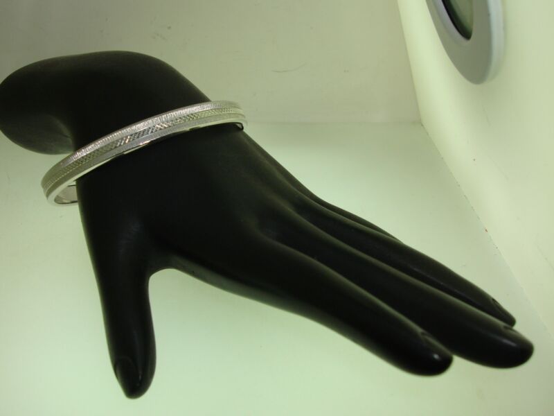 Vintage Monet silver bangle bracelet from the 1970s with a brushed cross-hatch design.
