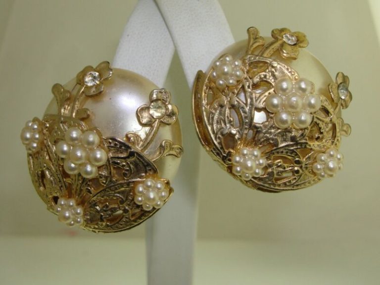 Vintage 1950s clip-on earrings with ornate gold filigree, faux pearl, and rhinestone details.