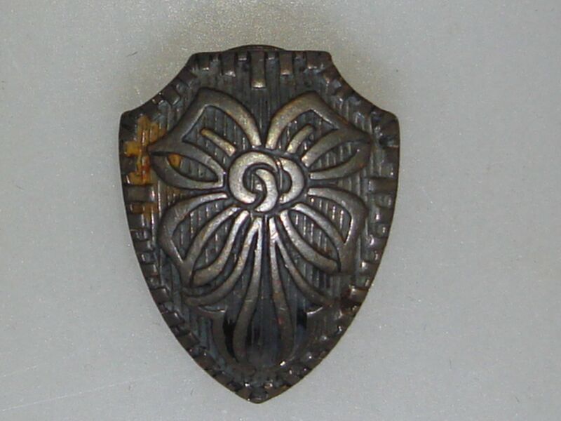 Antique Art Nouveau silver button cover with a shield shape and bow embellishment.