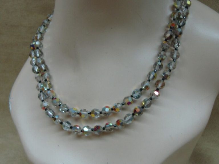 Two vintage 1980s Aurora Borealis crystal necklaces with clear/gray crystals and pink/gold hues.