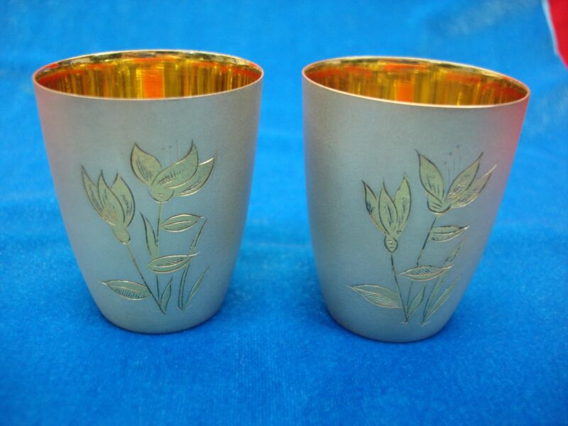 Set of two authentic Russian silver shot glasses, engraved and gold accented.