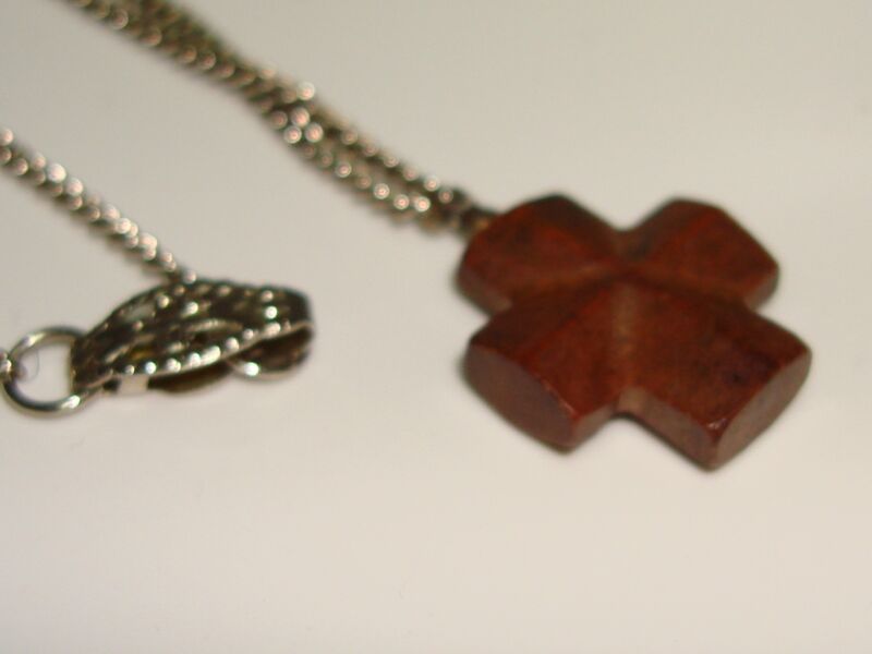 Antique carved rosewood cross pendant necklace with a silver chain.