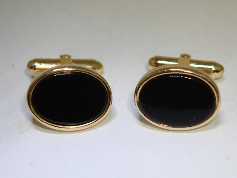 Vintage gold-tone cufflinks with black onyx stones in a unique angled setting.