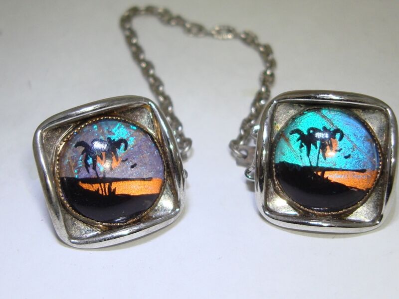 Vintage 1960s sweater clips with lucite butterfly wings and palm tree/ocean scene inlay.
