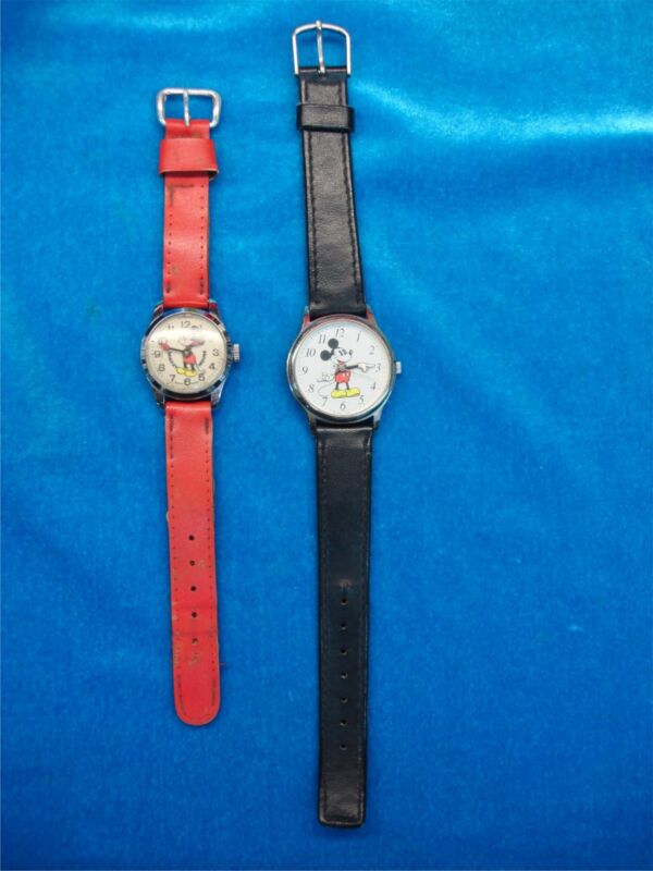 Vintage Mickey Mouse wristwatch pair, one stem-wind and one quartz, for collectible or repair purposes.
