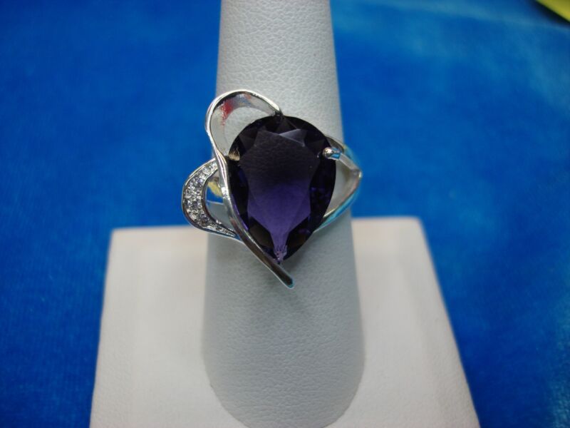 Sterling silver cocktail ring with a purple pear-shaped stone and clear accents