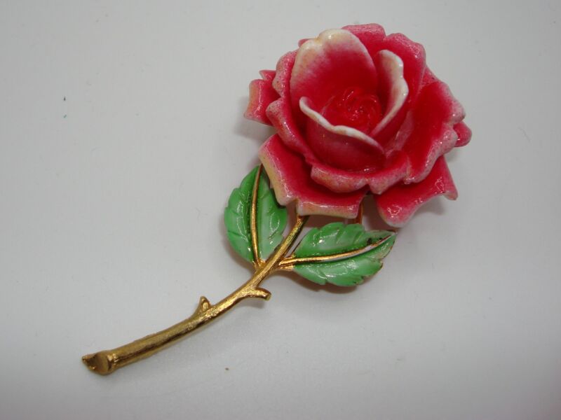 Vintage gold-tone floral pin with pink and white lucite petals, green enamel leaves, signed J.J.