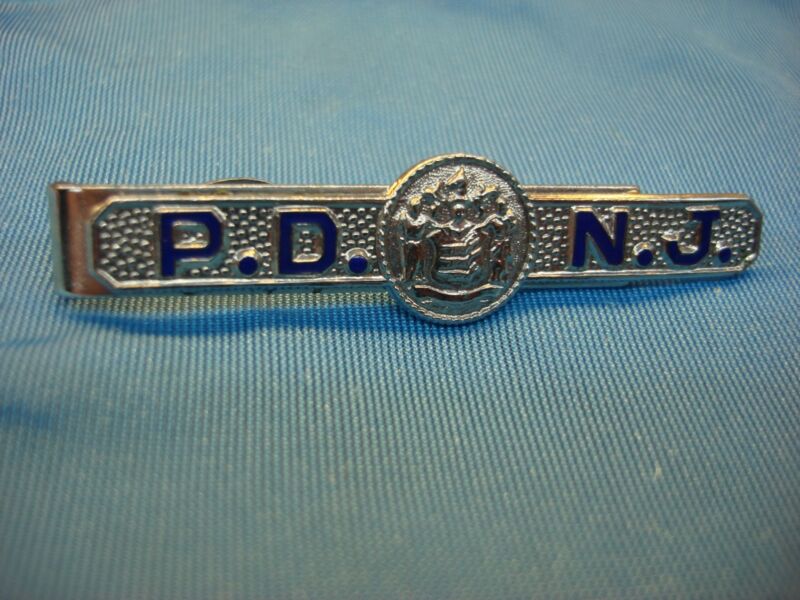Vintage chrome tie clip featuring a design possibly representing New Jersey law enforcement.