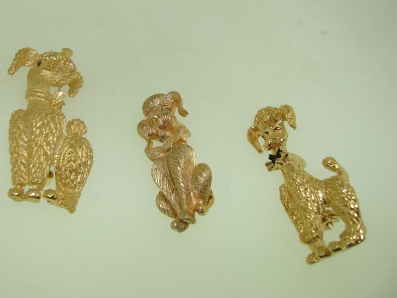 Set of three vintage 1960s gold tone poodle dog pins with rhinestone eyes