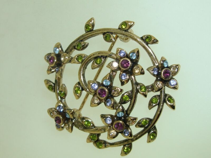 Vintage Monet rhinestone pin with a gold-tone swirl design