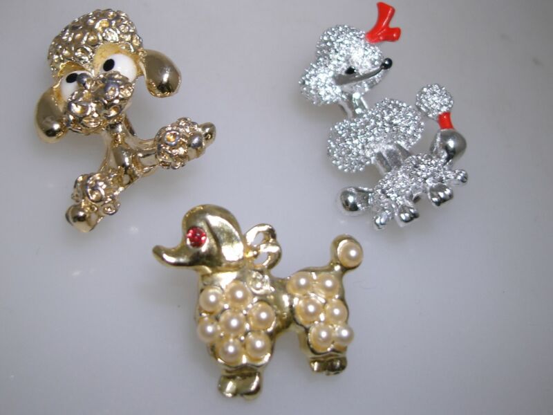 Set of three vintage poodle dog scatter pins in gold, silver, and pearl enamel