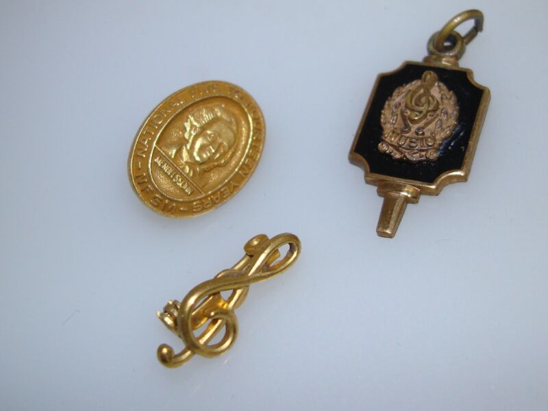 Vintage collegiate music award pins from the 1940s-1950s featuring a G clef, Mendelssohn, and key designs