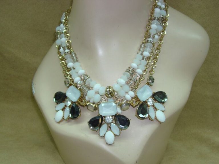 Gold-tone bib necklace with white and charcoal accents, signed Inc.