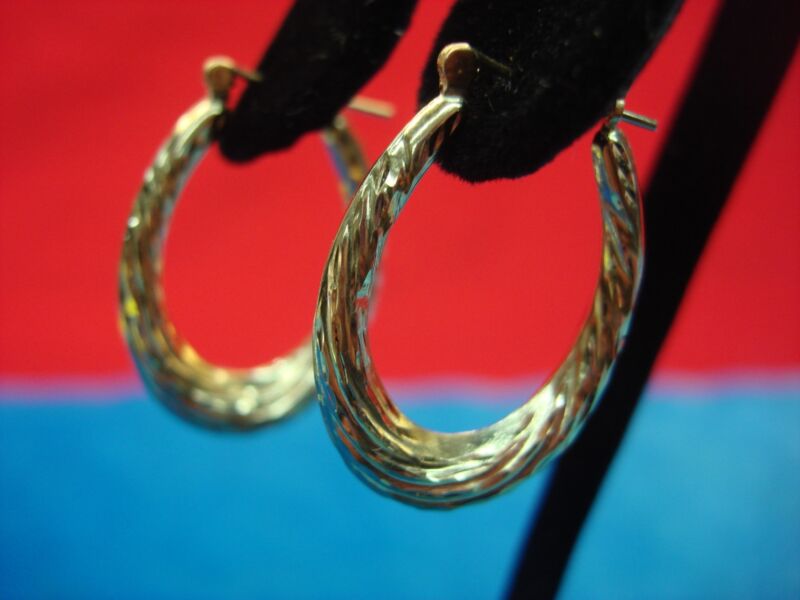 14K yellow gold puffy elongated hoop earrings with a fancy pattern