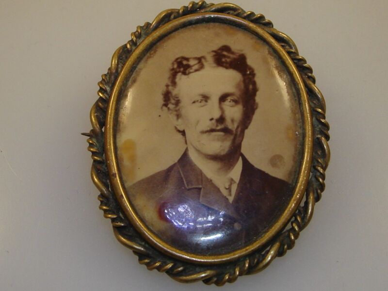 Antique Victorian sepia-tone pin featuring a handsome young man in a brass frame