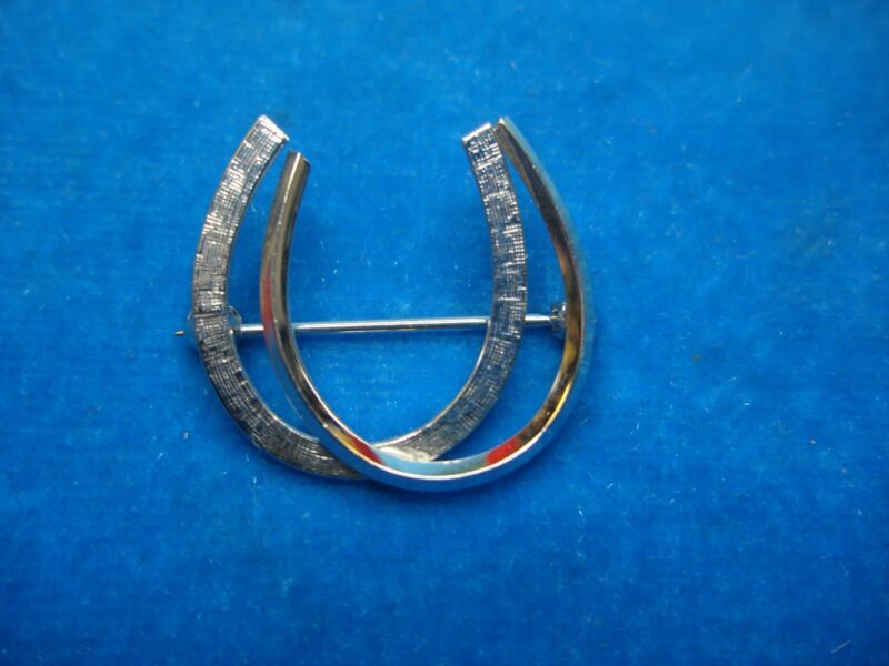 Vintage sterling silver double horseshoe pin with intricate design