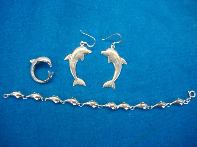 Sterling silver dolphin jewelry set featuring a bracelet, earrings and ring