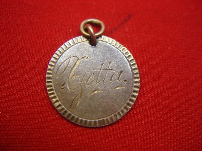Vintage silver dime bracelet featuring antique charms and a unique 'GETTA' 1888 love token.