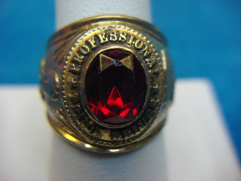 Vintage gold tone truck driver ring, size 10, with a red stone. Unique statement piece.