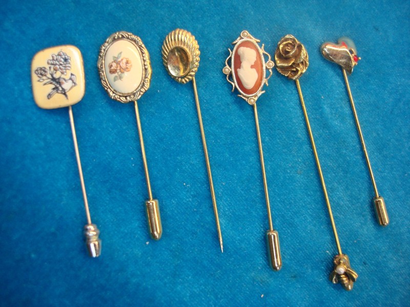 Collection of six vintage stick pins with unique enamel designs and some finger protectors.