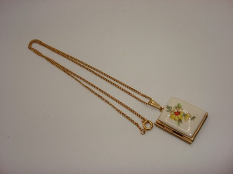 Vintage 1950s gold-tone porcelain locket necklace with two picture compartments.