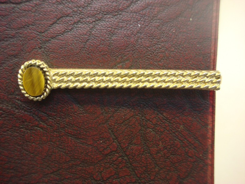 Vintage gold-tone tie clip with brown stone and intricate pattern