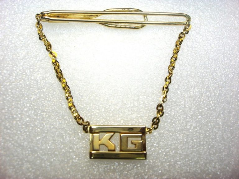Vintage gold-tone tie clip with leather accents and KG initials