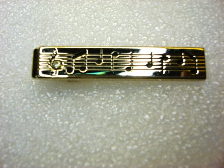 Vintage Swank gold-tone tie clip with musical notes and a simulated diamond accent. In nice condition.
