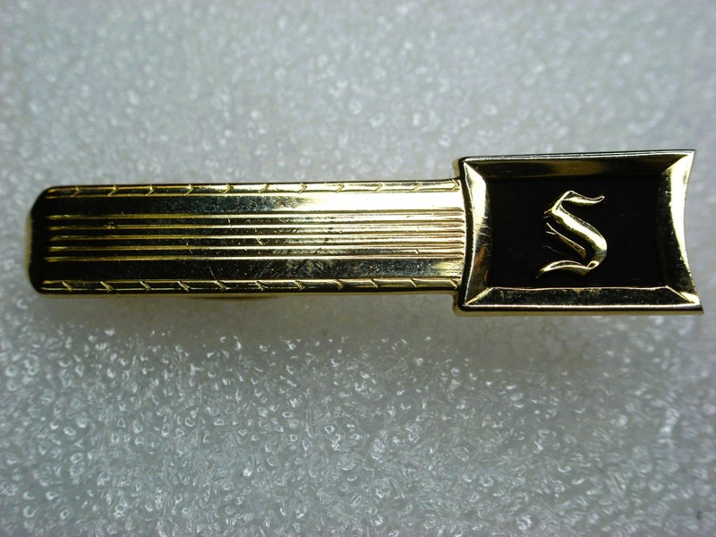 Vintage gold tone tie clip with initial 'S' and black enamel detailing