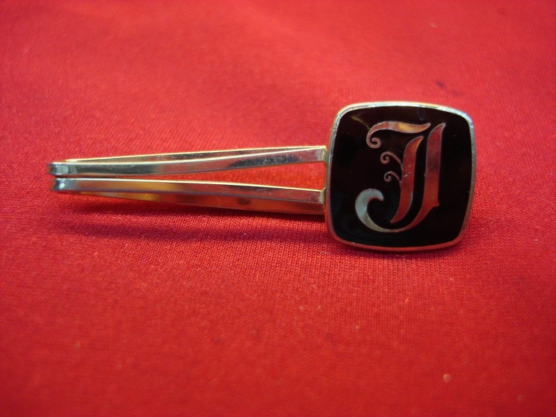 Vintage gold-tone tie clip with 'J' design and black enamel