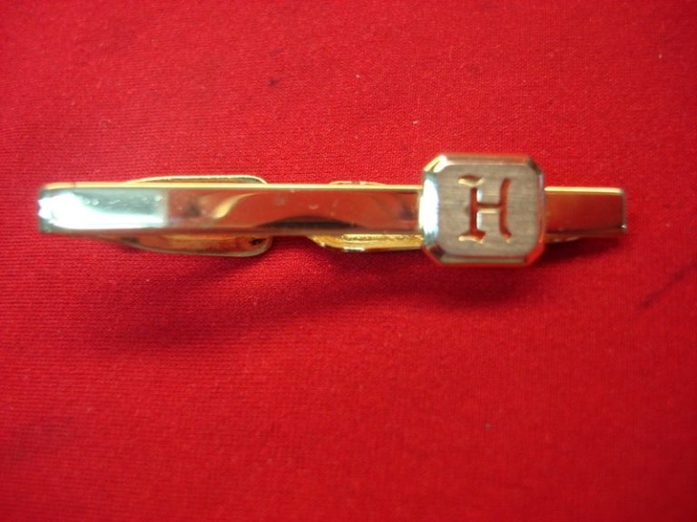 Vintage gold-tone tie clip with engraved 'H'