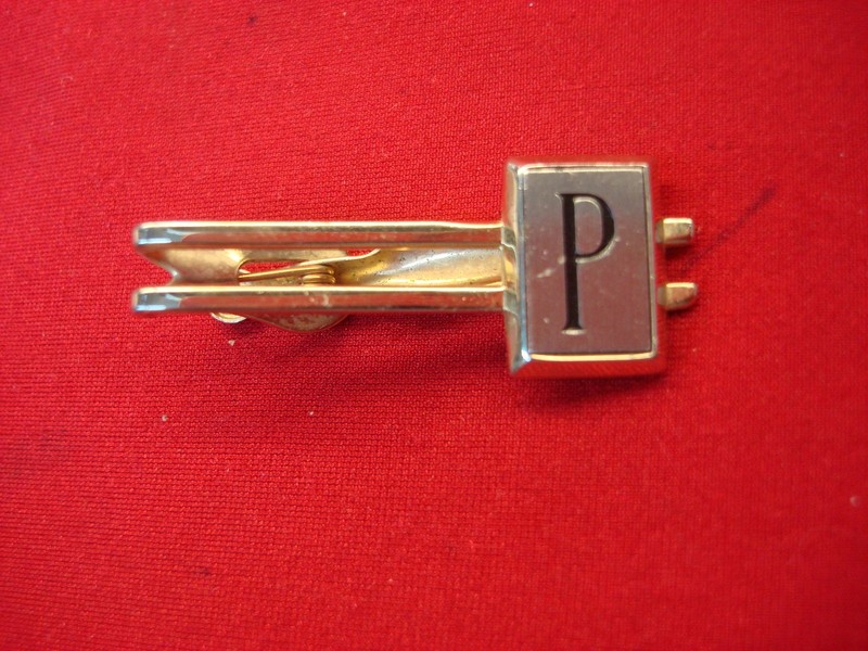 Vintage gold-tone tie clip with engraved 'P'