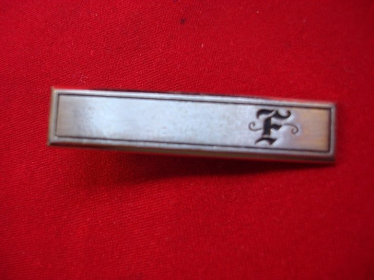 Vintage gold-tone tie clip with unique 'F' design