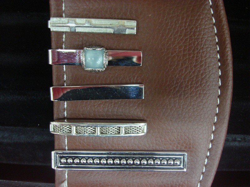 Five vintage silver tone tie clips in a pre-owned condition, each with unique designs.