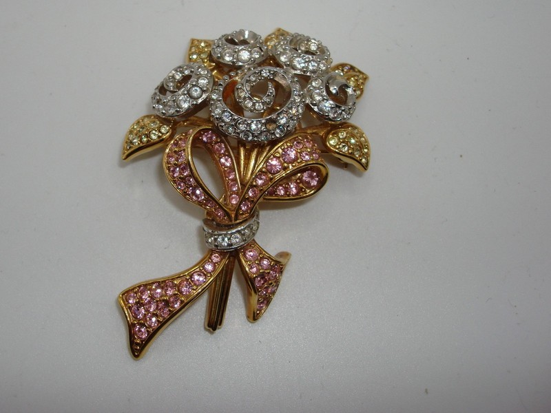 Vintage 1998 signed Swarovski brooch with '98JP' marking, featuring clear, pink, and amber crystals. One crystal is missing.