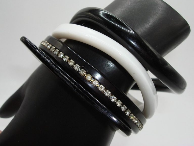 Set of four vintage black and white lucite bangle bracelets with rhinestone accents.