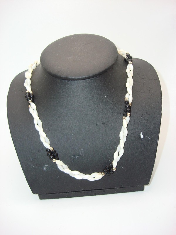 Vintage mother-of-pearl and onyx necklace with cream, black, and gold accents.